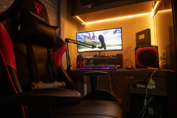 Pessoa usando cadeira gamer em setup completo com computador