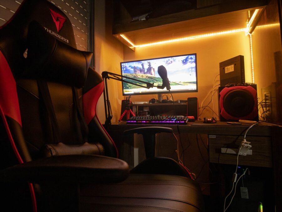 Pessoa usando cadeira gamer em setup completo com computador